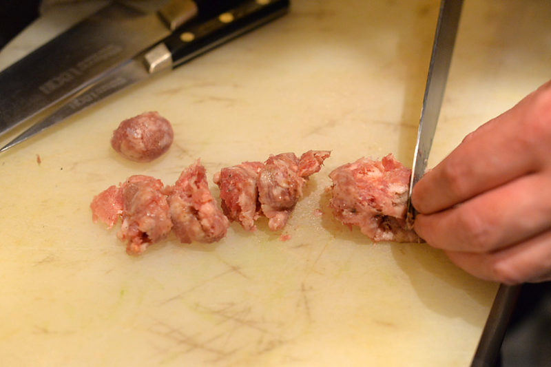 サルシッチャは皮をむいて食べやすいサイズに切ります