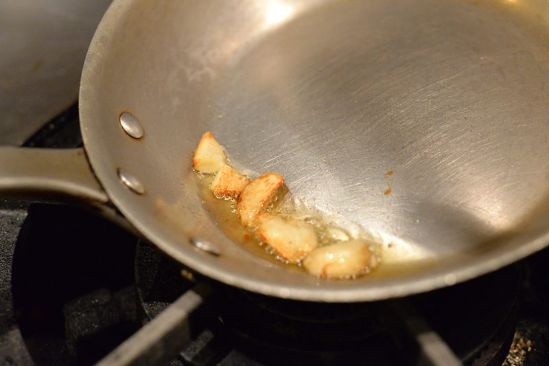にんにくがきつね色になり、温まってきたらサルシッチャ（ソーセージ）と唐辛子を種ごと一緒にいれて炒めます