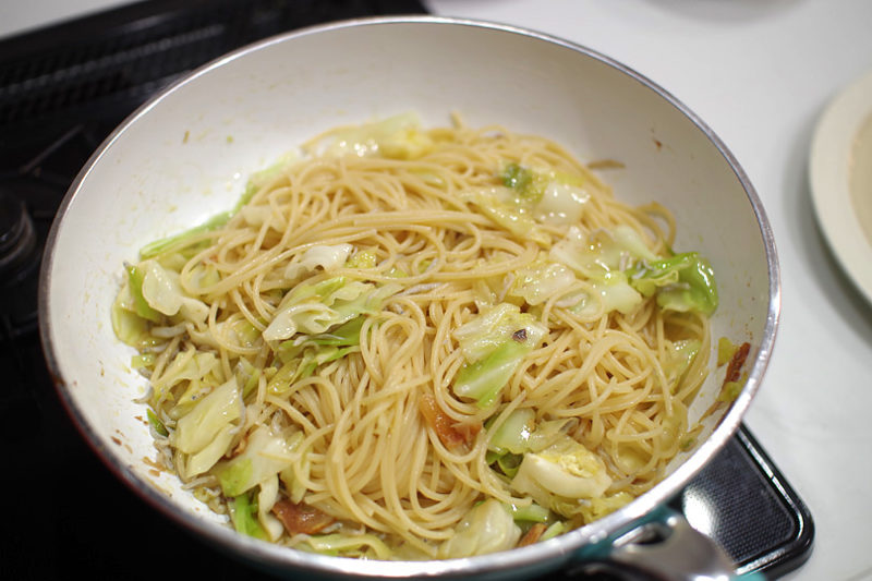 茹で上がったスパゲティをフライパンに加え、よく絡めます