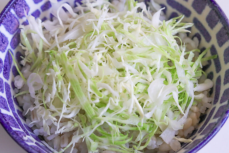 ごはんに千切りキャベツをのせる