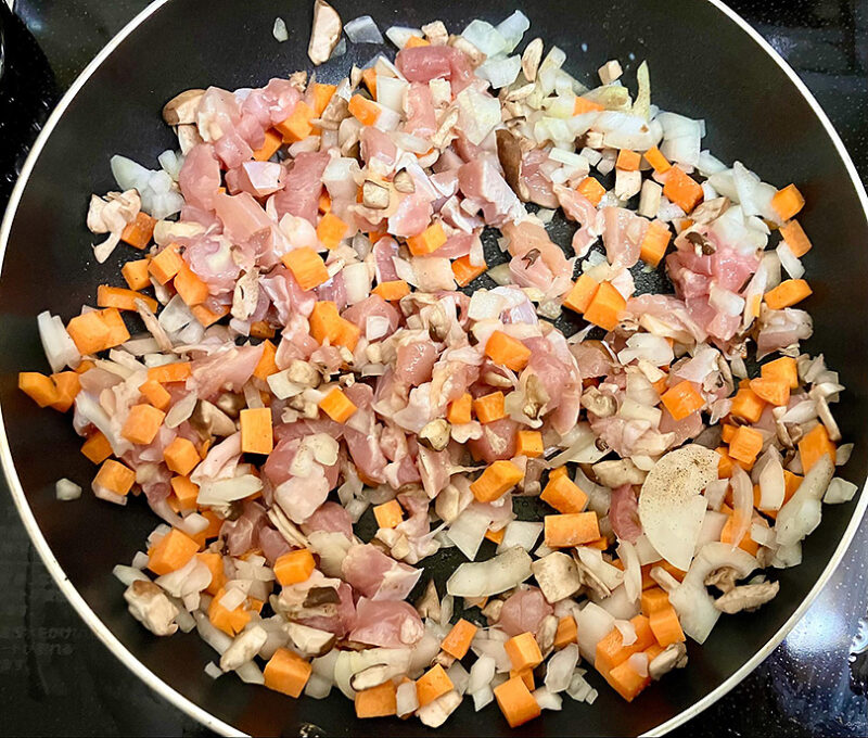 オリーブオイルで玉ねぎ、ピーマン、椎茸、鶏もも肉を炒める