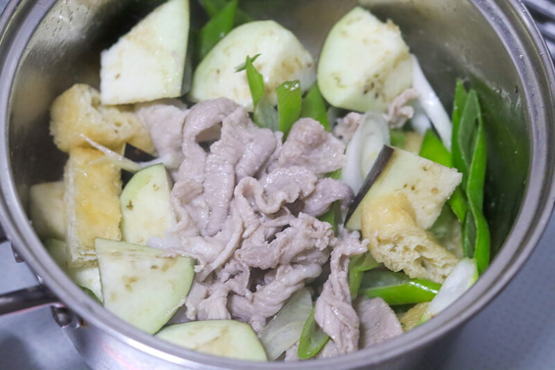 なす、長ねぎ、油揚げを加える